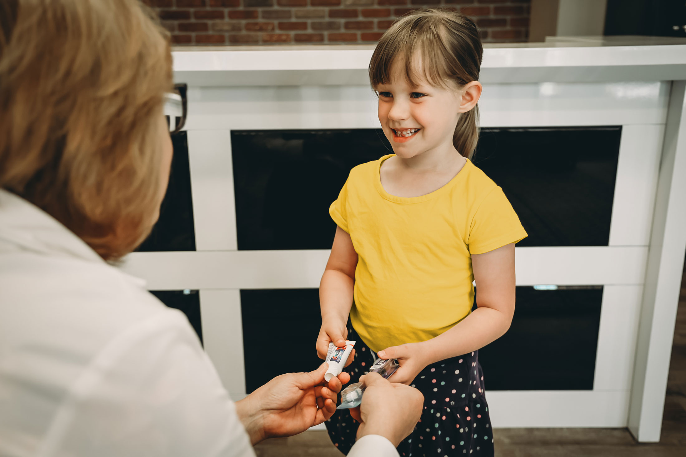 Young girl receiving tooth brush and tooth paste after medical visit