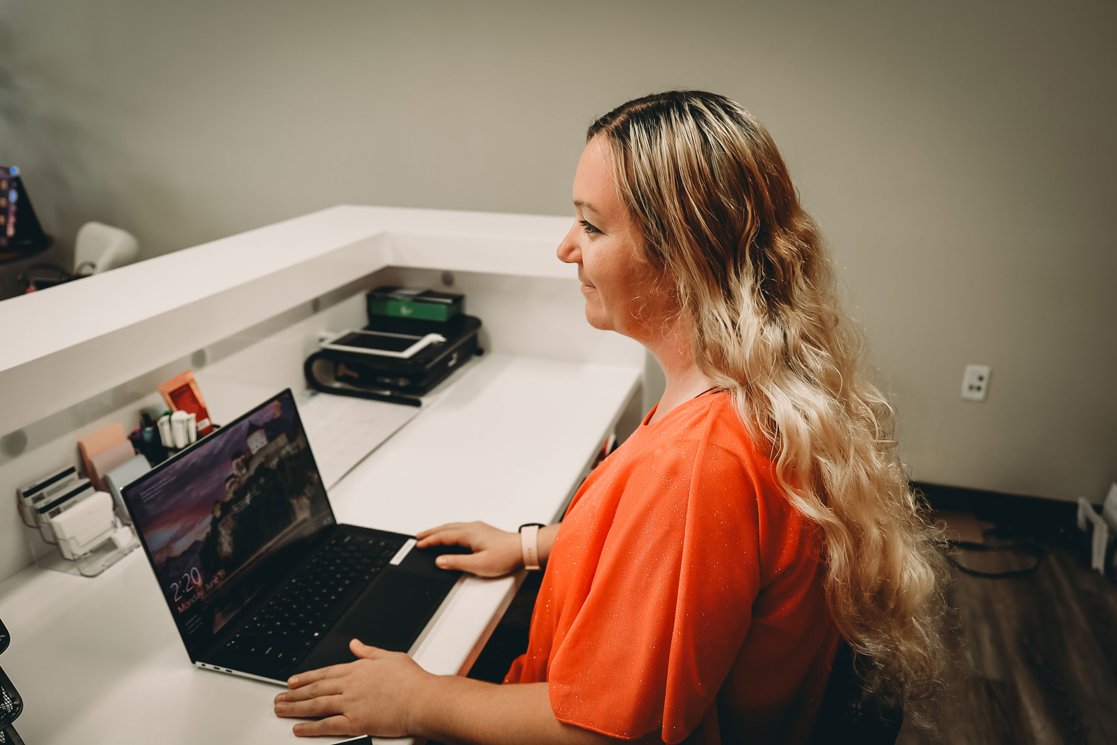 Woman on computer at front desk of medical office